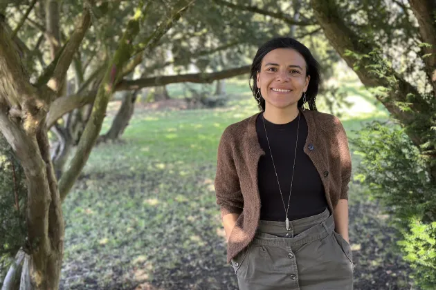 Jesica standing next to a tree. Photo